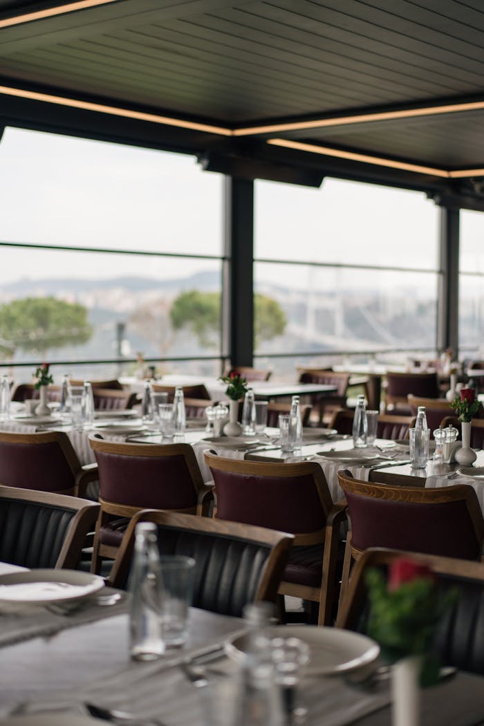 A sophisticated restaurant setup with table settings and a scenic view outside, perfect for dining.